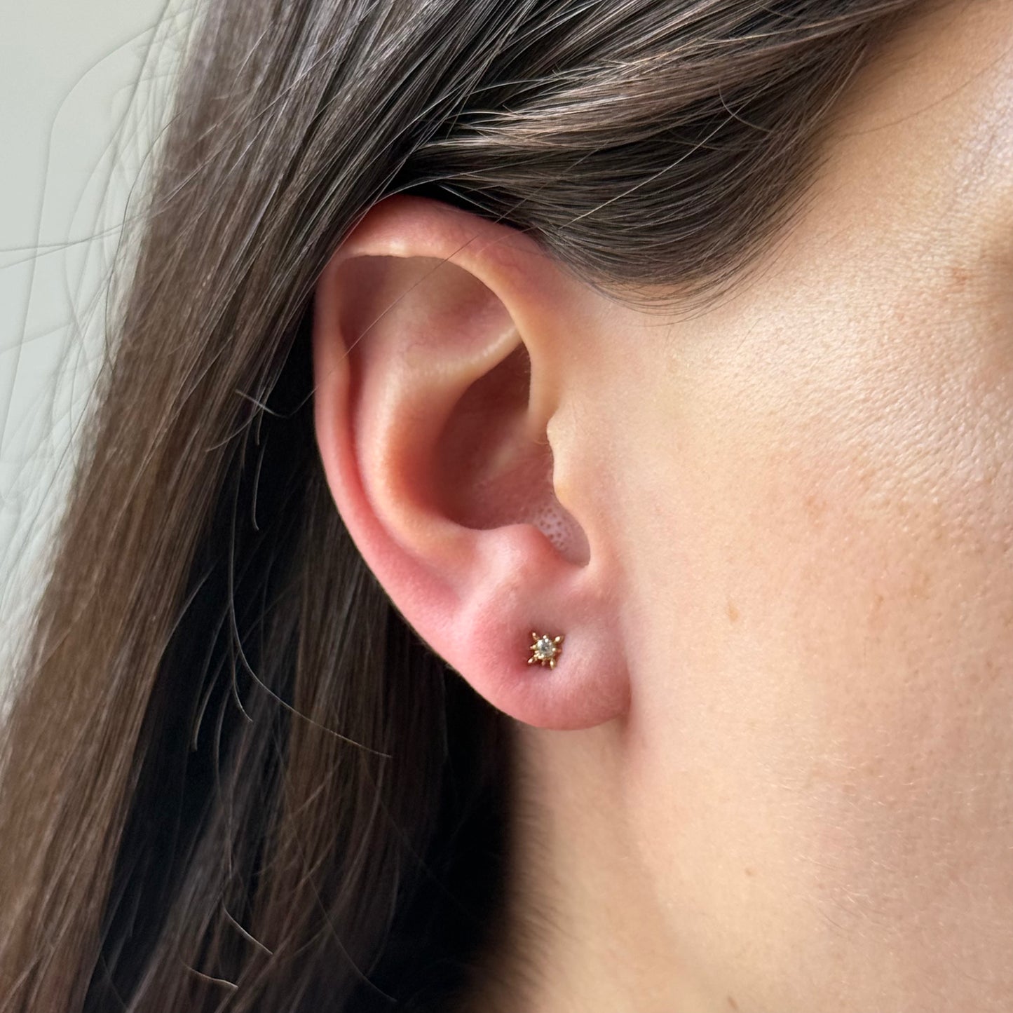 Aretes de estrella de ocho puntas con circonita redonda blanca en el centro en oro amarillo 14k con tope rosca