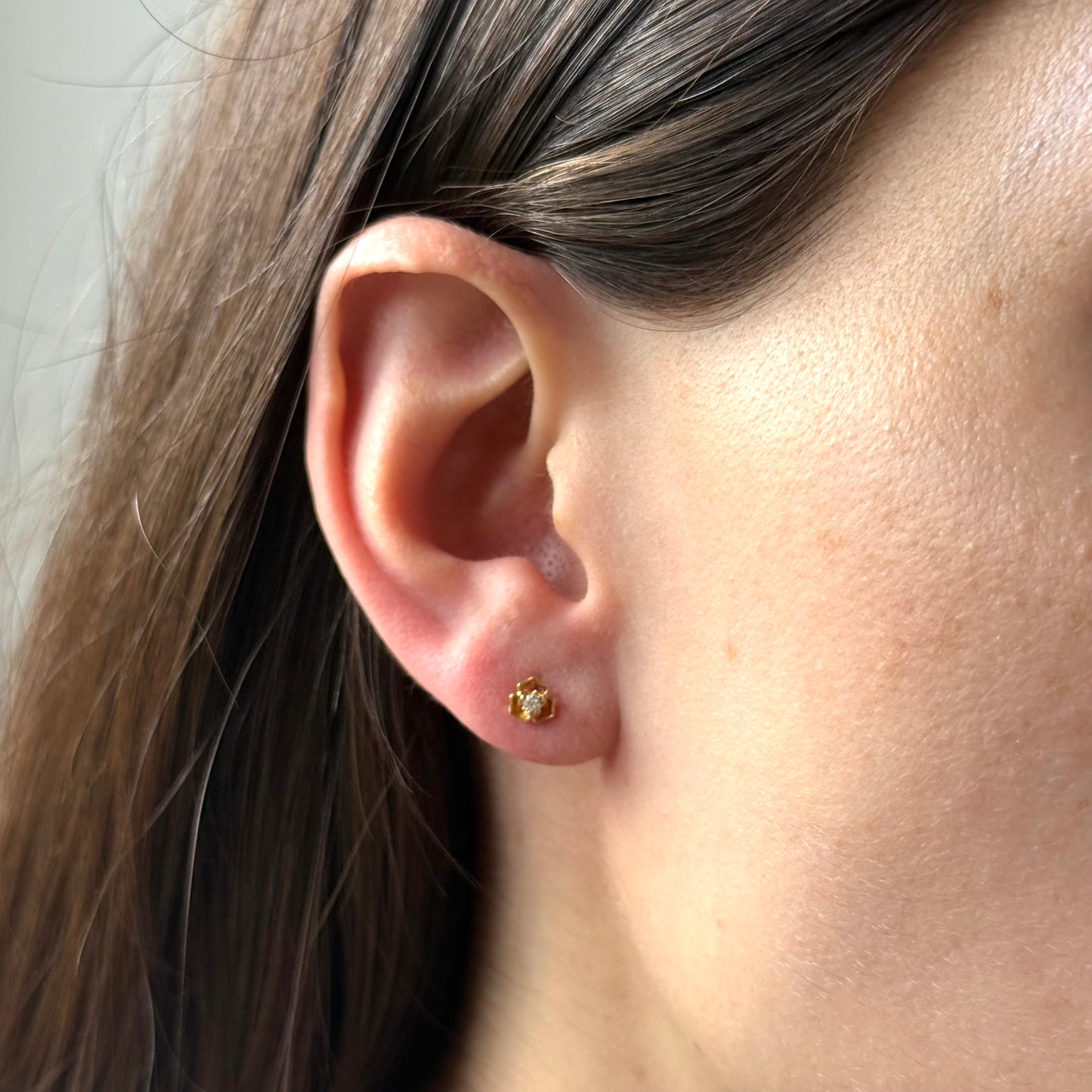 Arete de tres pétalos con circonita blanca en el centro en oro amarillo 14k con tope rosca