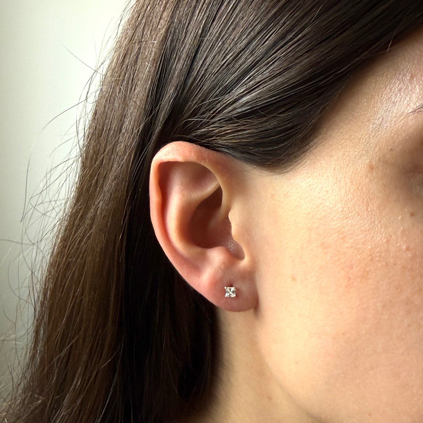 Aretes en oro amarillo 18K con circonita cuadrada blanca con tope rosca