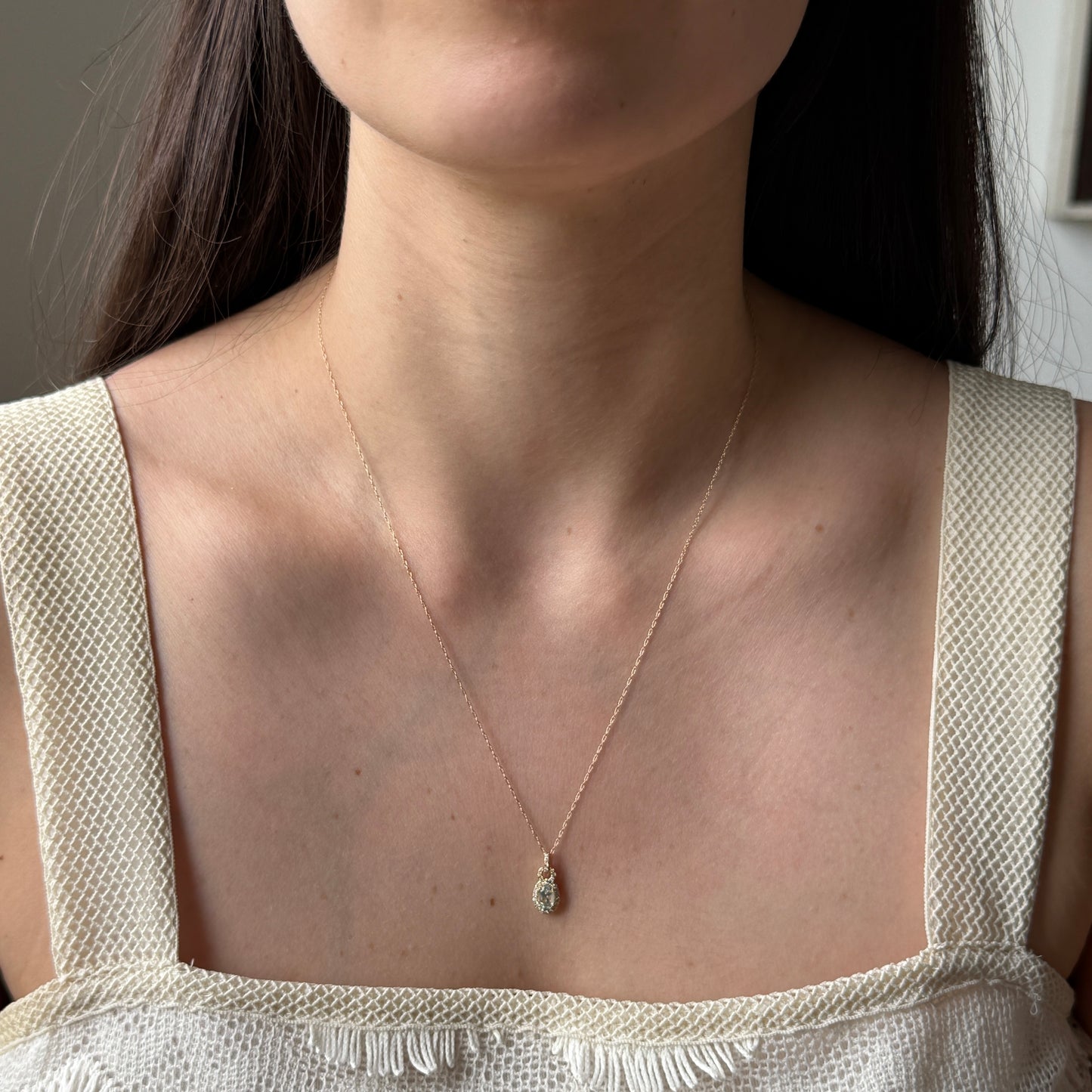 Collar en oro amarillo 10k con aguamarina ovalada con pasacadena y halo de diamantes 0.18ctw