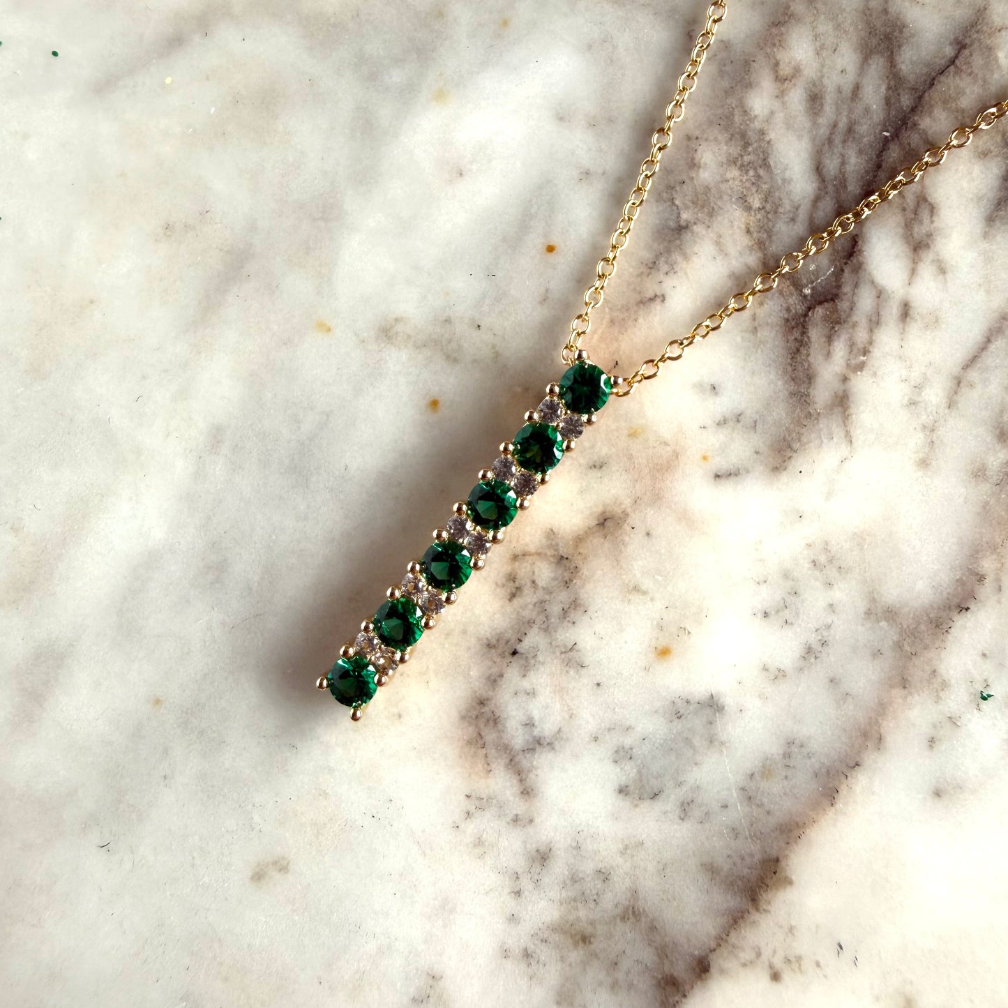 Cadena de plata con baño de oro amarillo con dije de barra  de esmeraldas y zafiros blancos de laboratorio