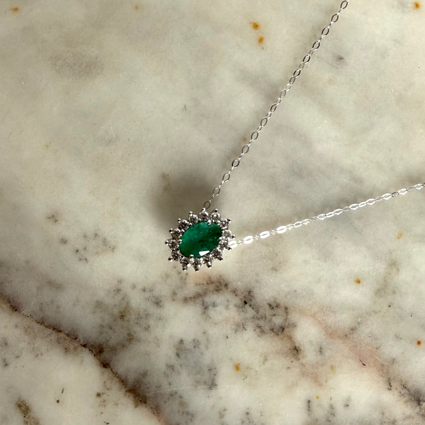 Collar en oro blanco 14K con esmeralda ovalada y halo de diamantes 0.20ctw