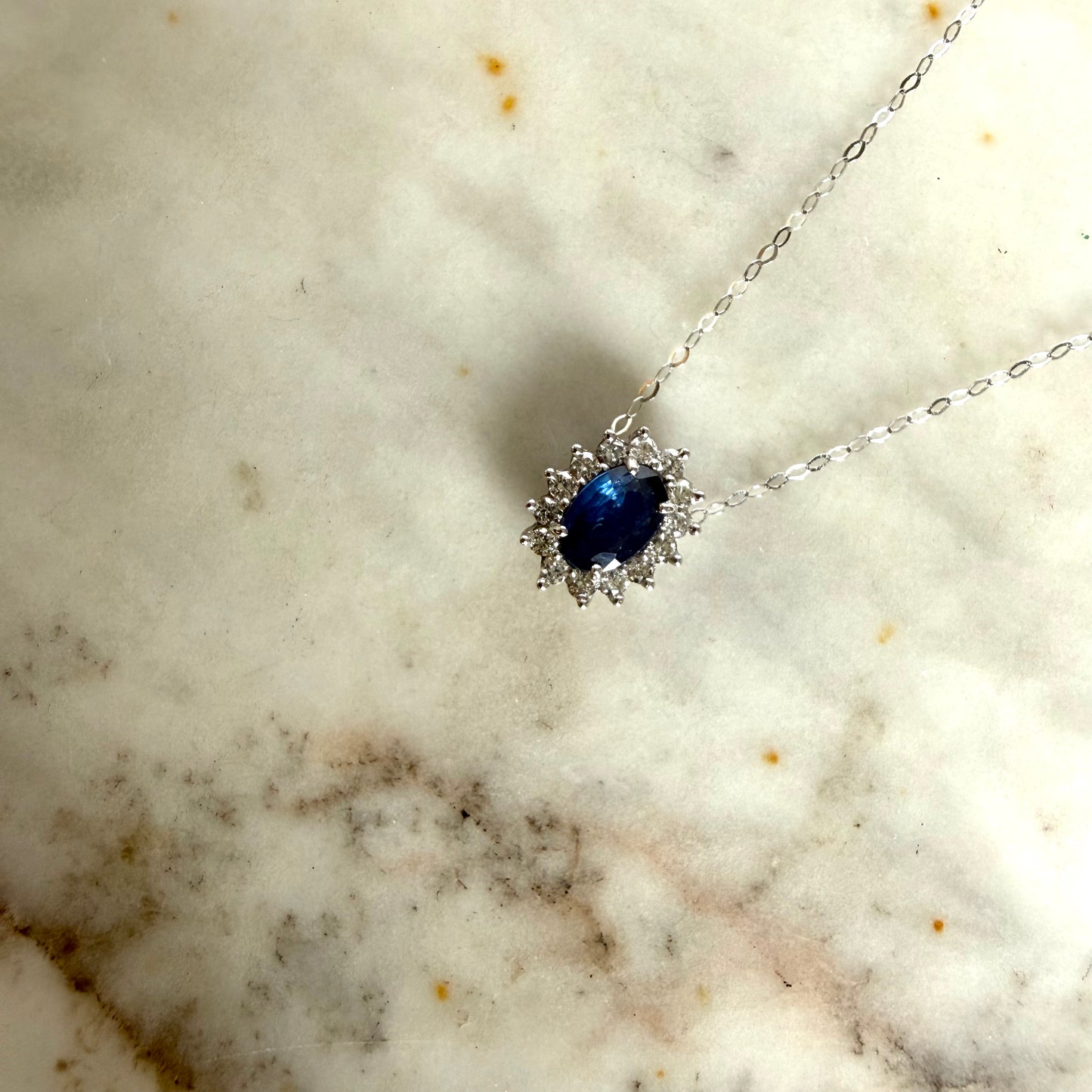 Collar en oro blanco 14K con zafiro ovalado y halo de diamantes 0.20ctw