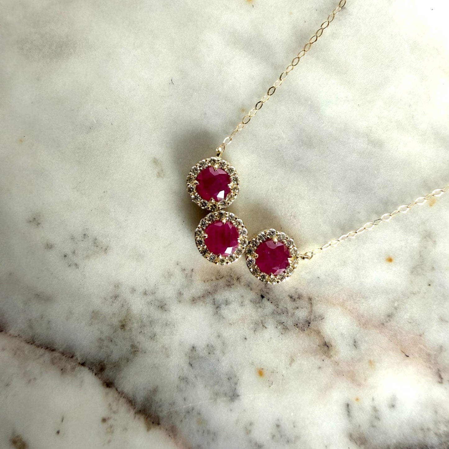 Collar en oro amarillo 14K con rubíes redondos y halo de diamantes 0.25ctw