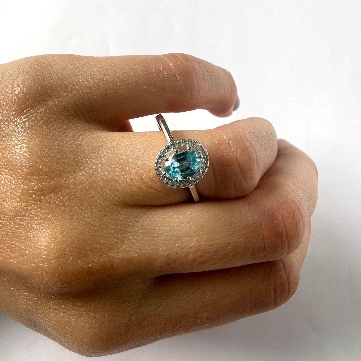 Anillo de plata con topacio azul ovalado y halo de circones