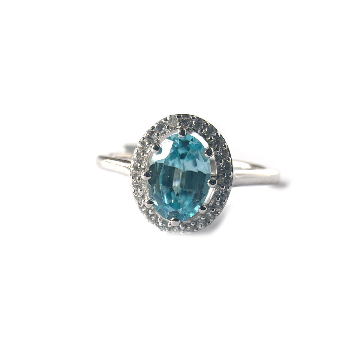 Anillo de plata con topacio azul ovalado y halo de circones