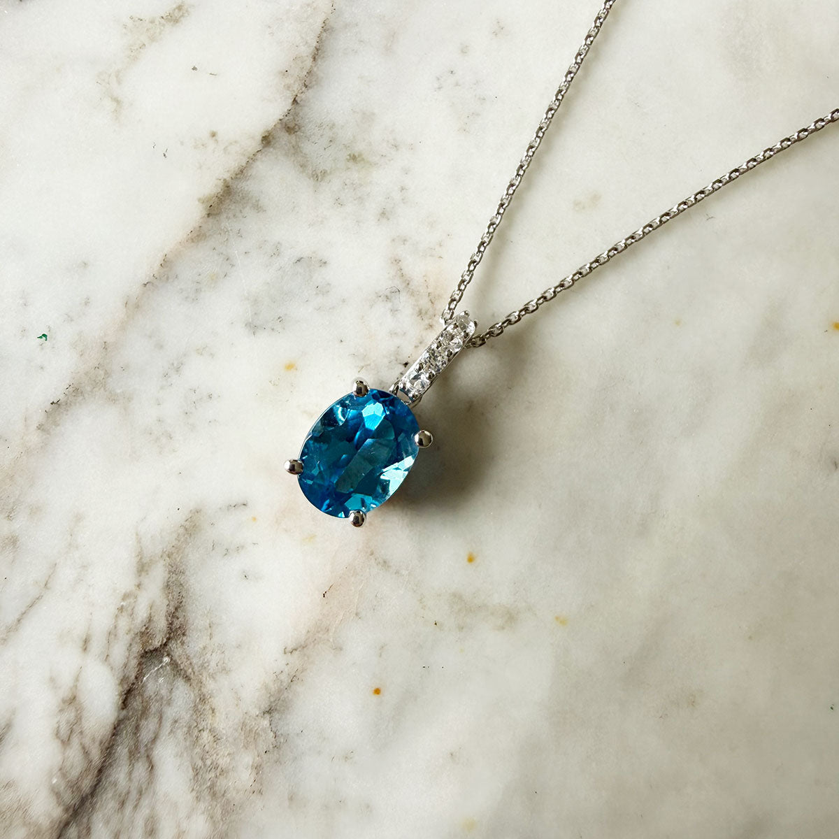 Cadena de plata con dije de topacio azul y zafiros blancos