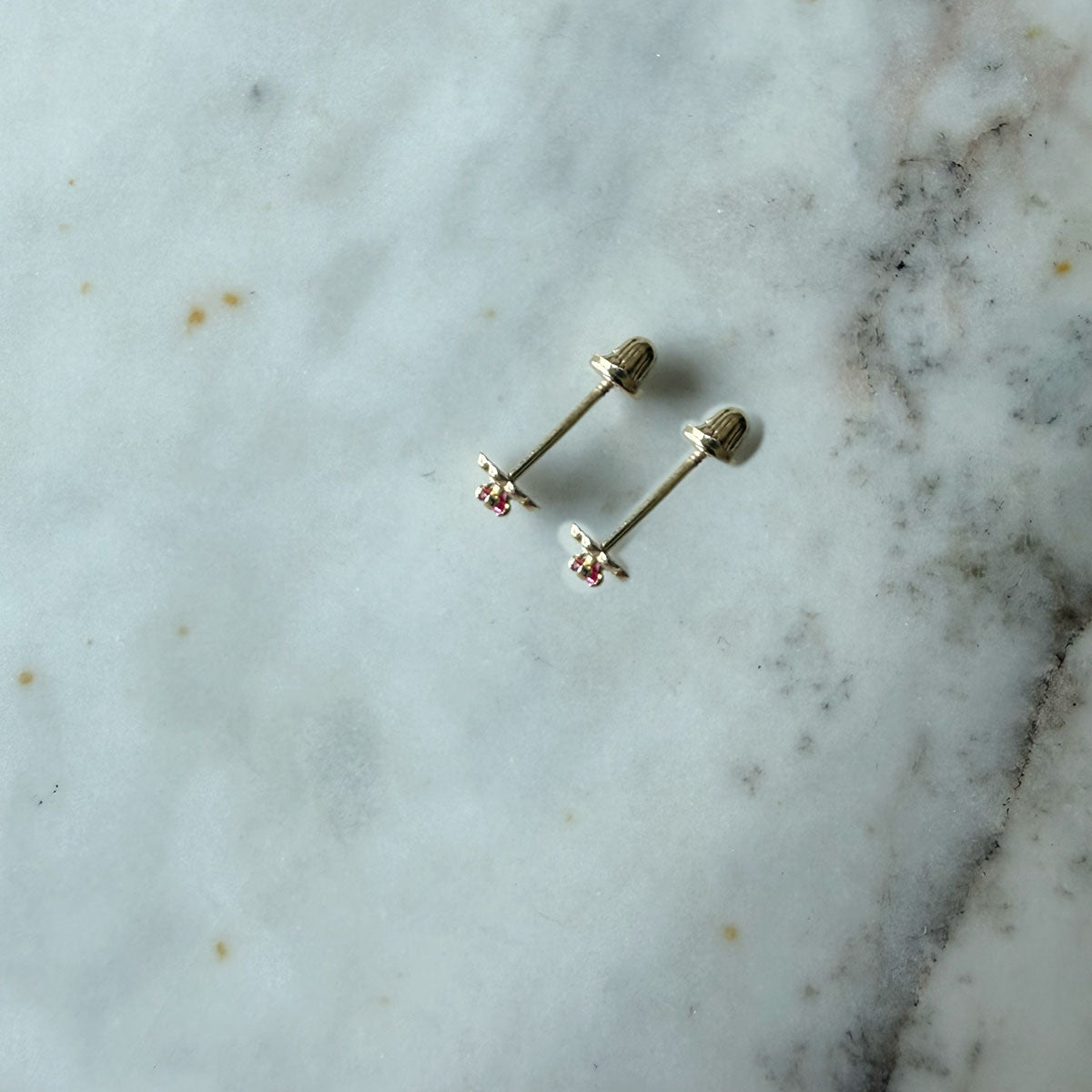 Aretes en oro amarillo 14K con flor de pétalos de oro y circonita fucsia con tope rosca