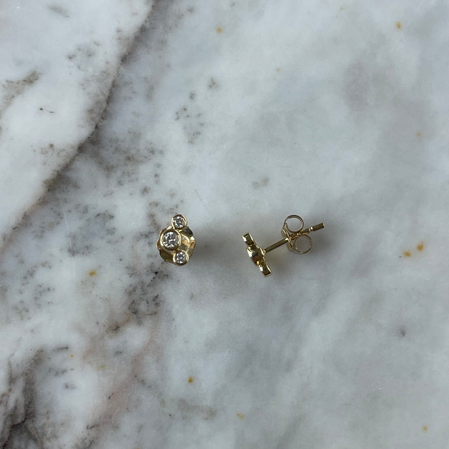 Aretes de tres diamantes redondos biselados 0.18 ctw en oro amarillo 10k