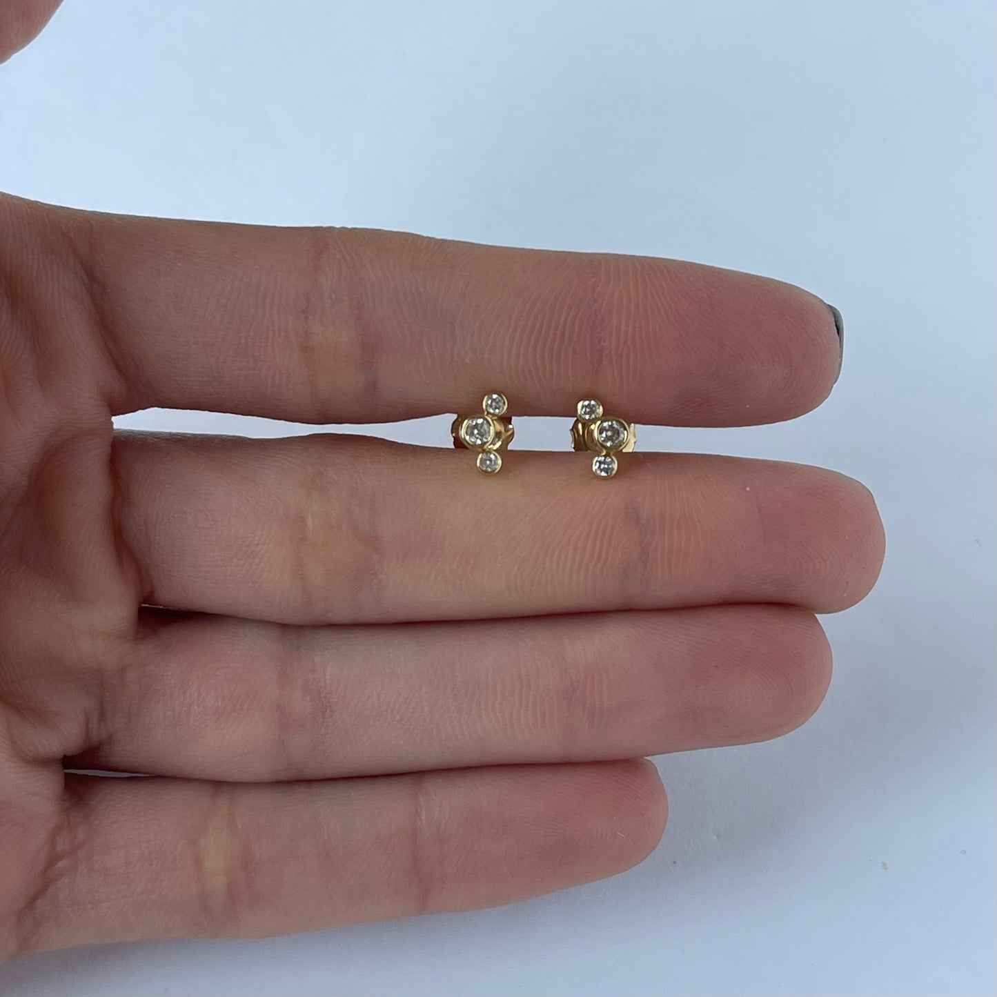 Aretes de tres diamantes redondos biselados 0.18 ctw en oro amarillo 10k