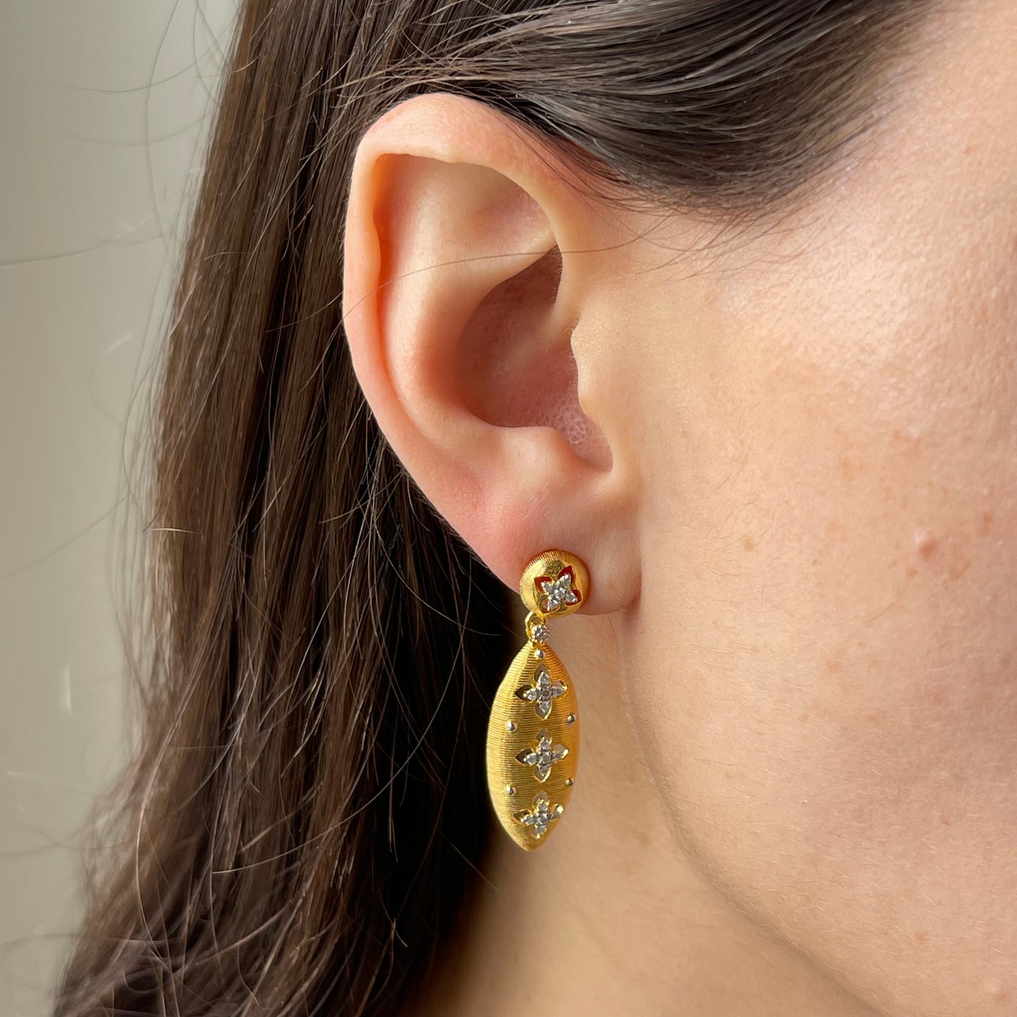 Aretes de plata con baño de oro con detalles de flores de moissanitas