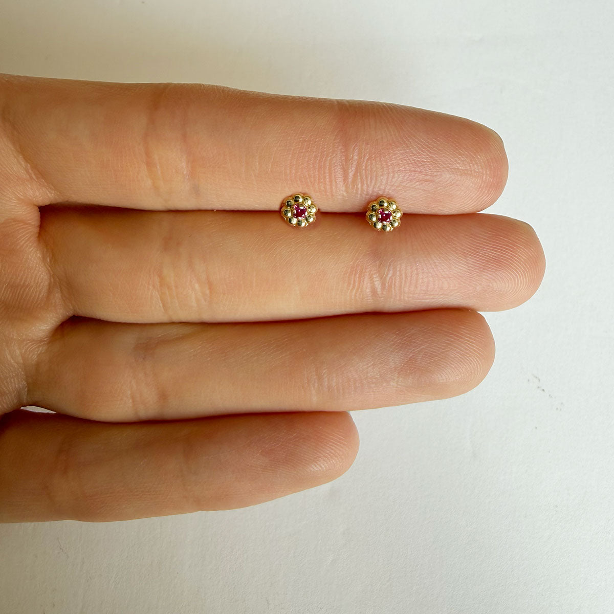 Aretes en oro amarillo 14K con flor de pétalos de oro y circonita fucsia con tope rosca