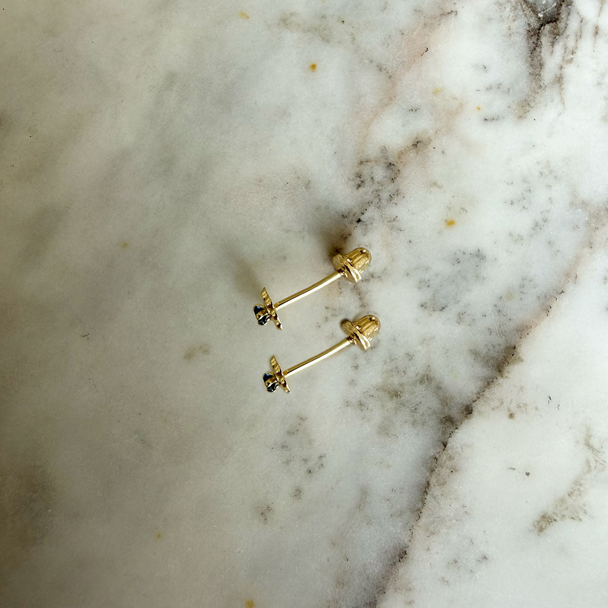 Aretes en oro amarillo 14K con flor de pétalos de oro y circonita azul con tope rosca