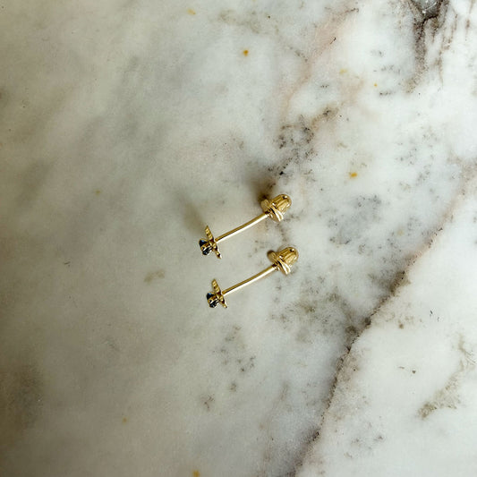 Aretes en oro amarillo 14K con flor de pétalos de oro y circonita azul con tope rosca