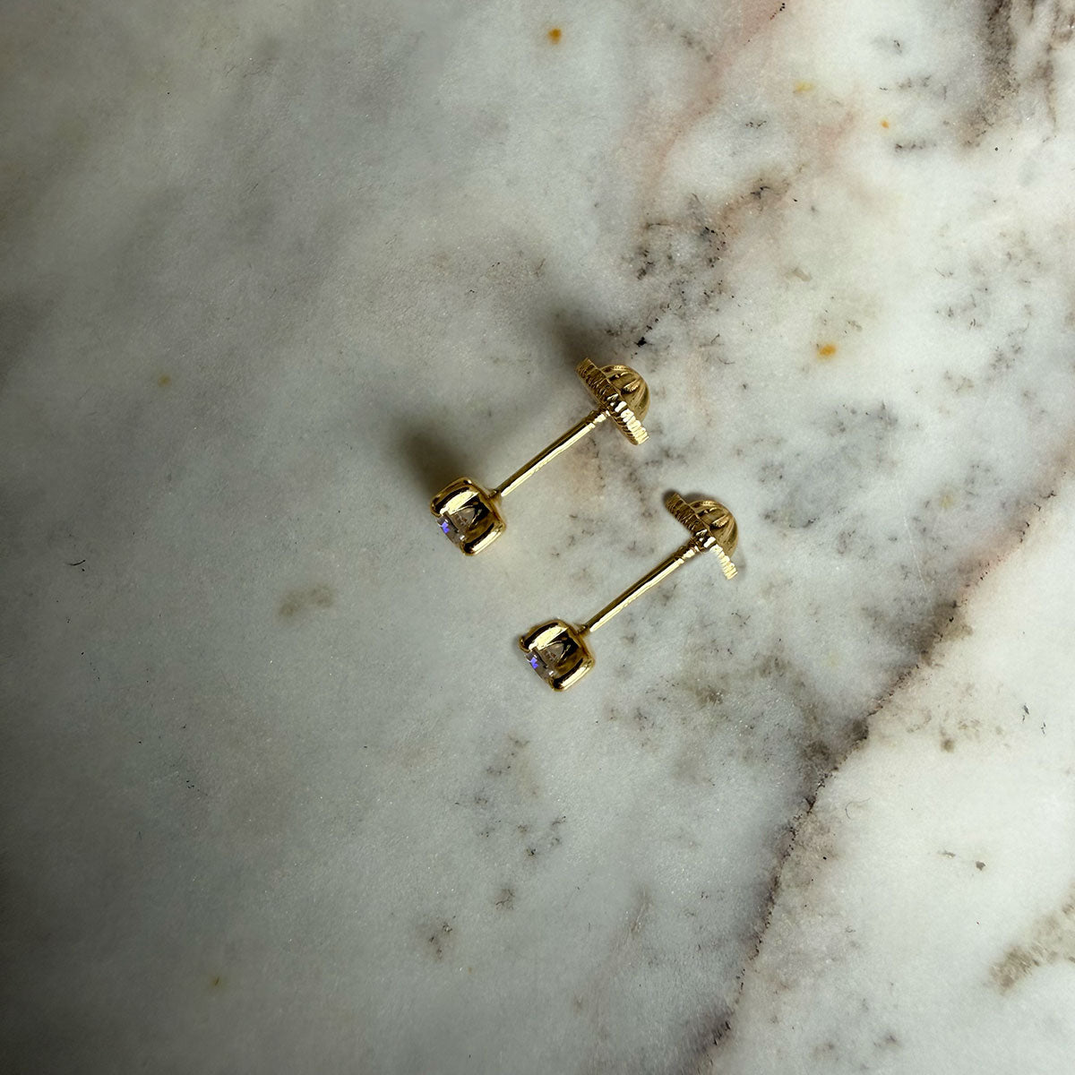Aretes circón blanco con cuatro agarres en oro amarillo 18K con tope rosca
