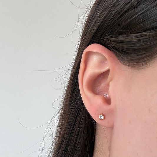 Aretes circón blanco con cuatro agarres en oro amarillo 18K con tope rosca