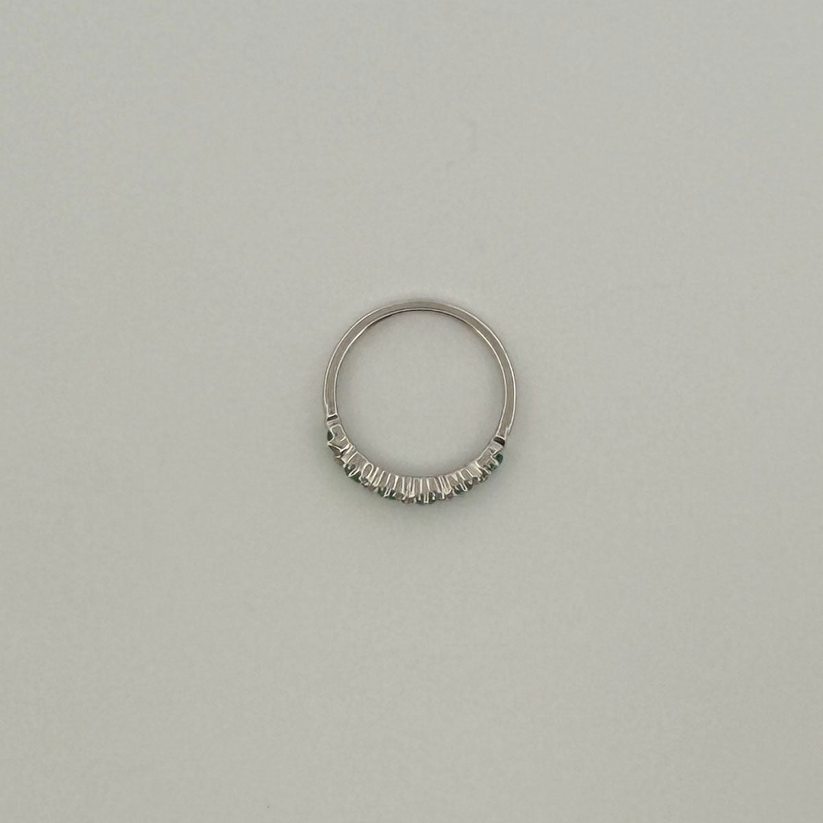 Anillo medio cintillo en oro blanco 10K con esmeraldas y diamantes en x