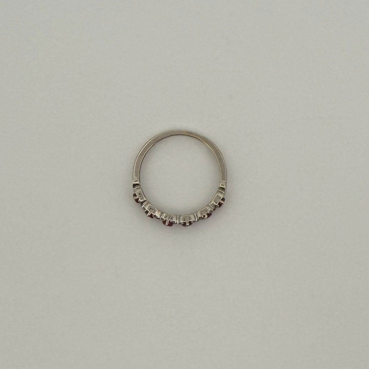 Anillo medio cintillo en oro blanco 10K con rubíes y diamantes en x