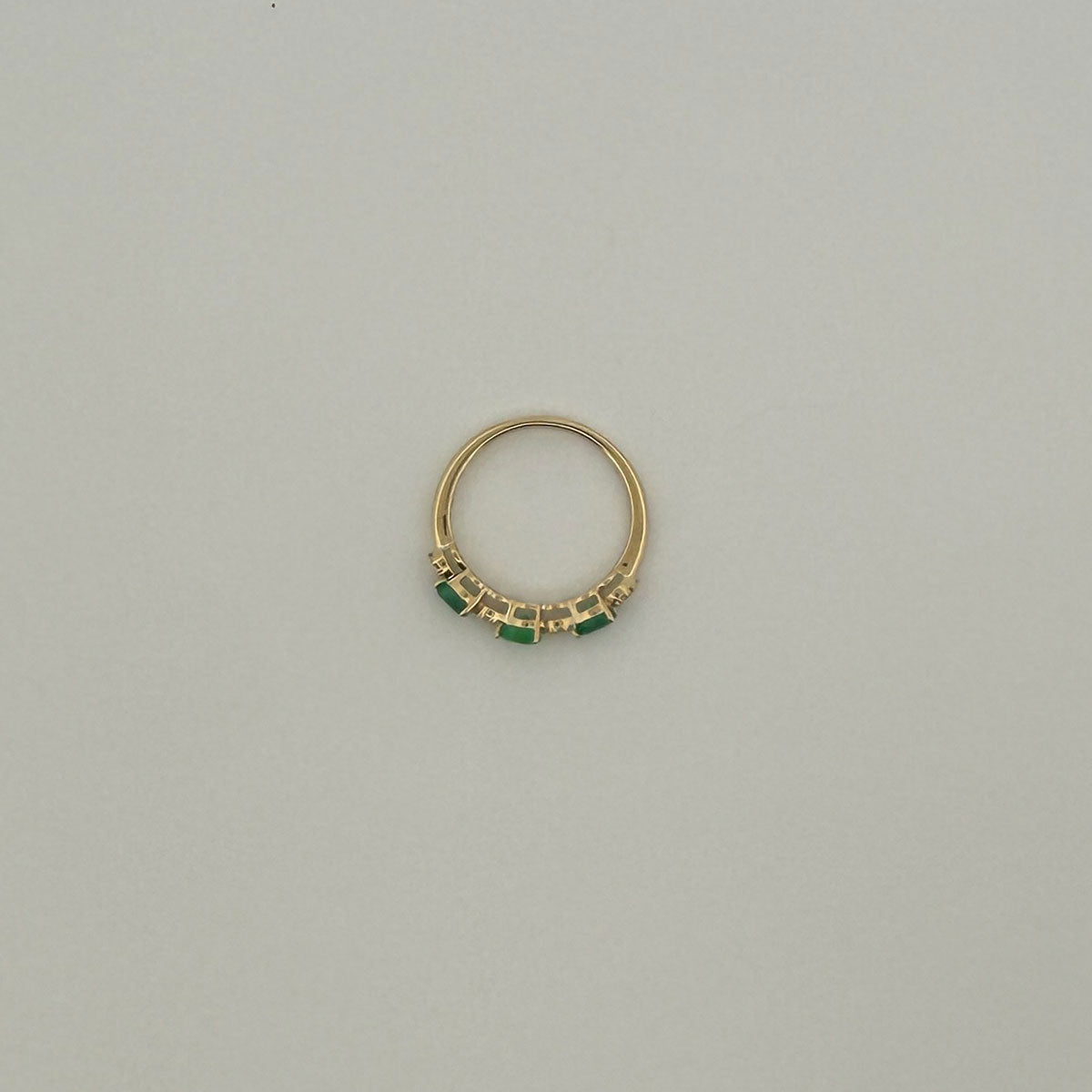 Anillo medio cintillo en oro amarillo 10K con esmeralda corte pera y diamantes 0.10ctw