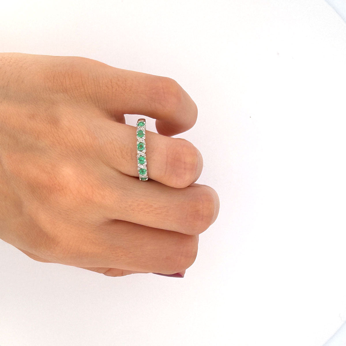 Anillo medio cintillo en oro blanco 10K con esmeraldas y diamantes en x