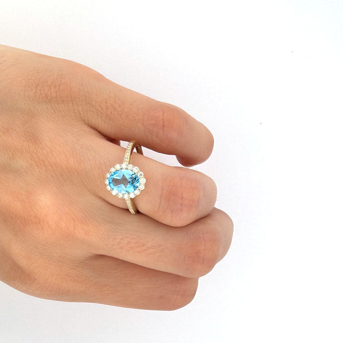 Anillo en oro amarillo 10K con topacio azul ovalado y halo de diamantes 0.35ctw
