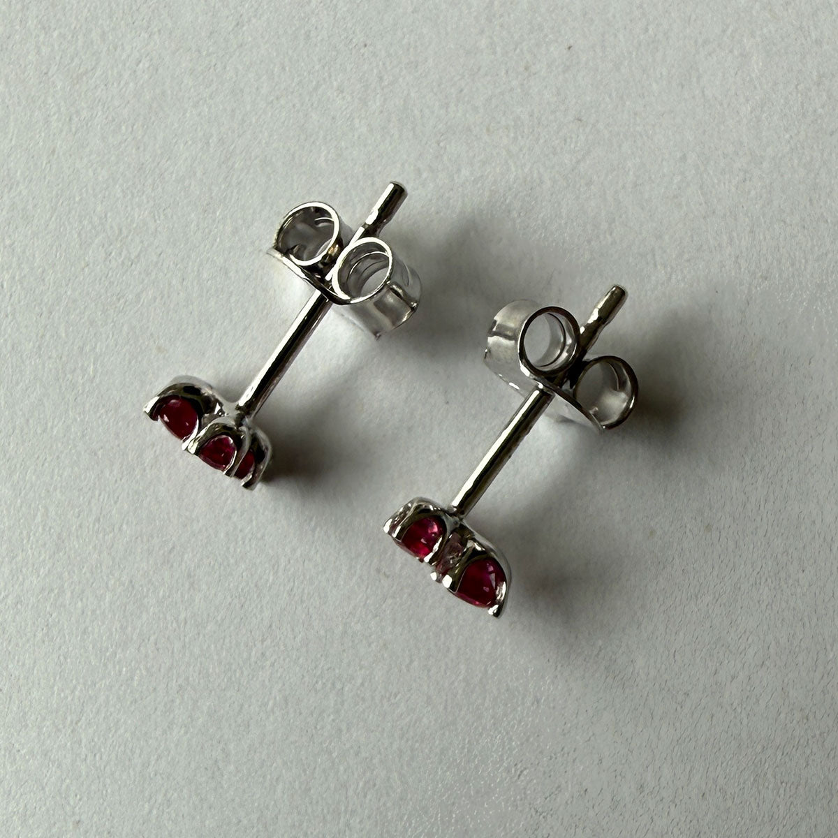 Aretes en oro blanco 14K con tres rubíes redondos