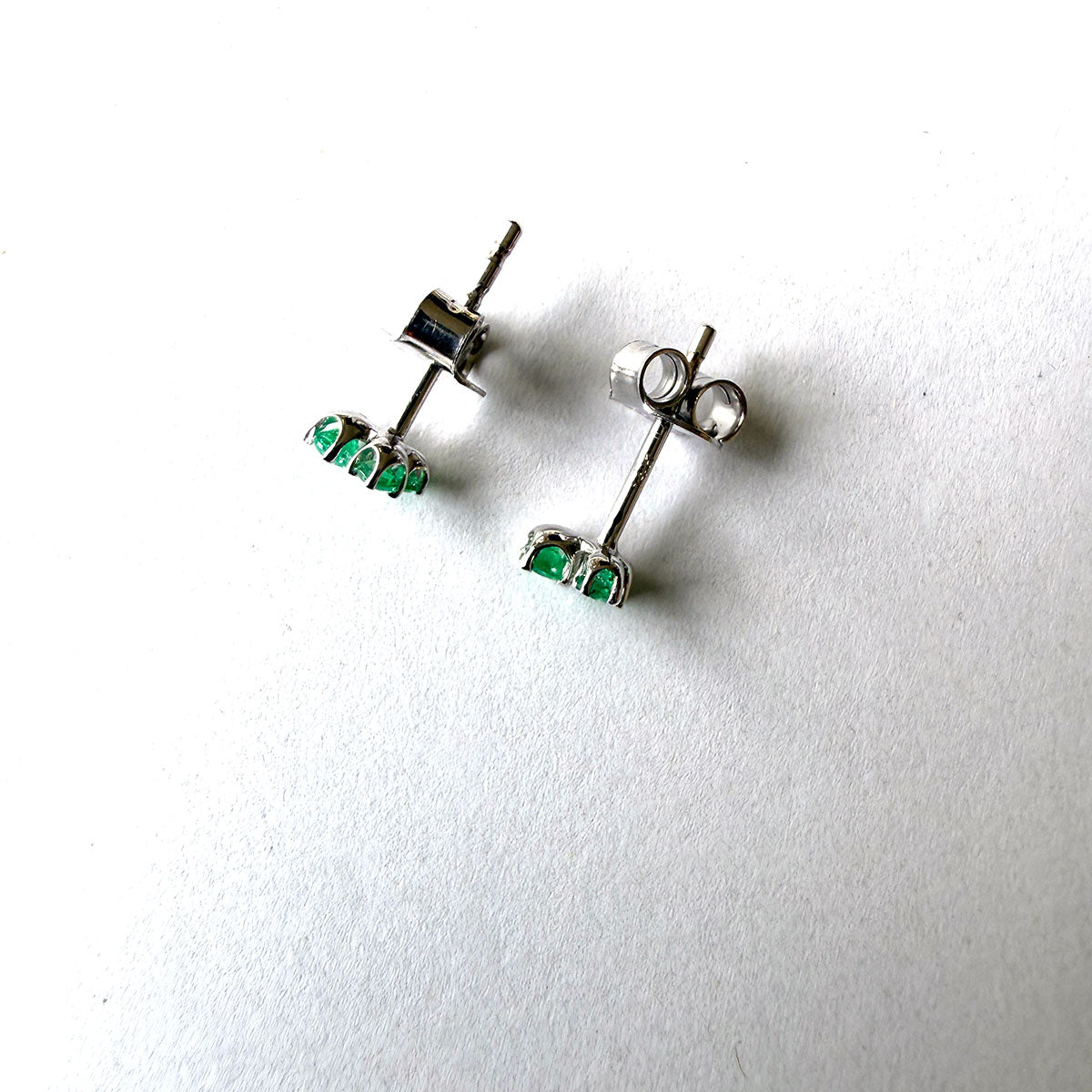 Aretes en oro blanco 14K con tres esmeraldas redondas