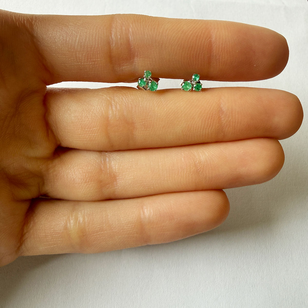 Aretes en oro blanco 14K con tres esmeraldas redondas