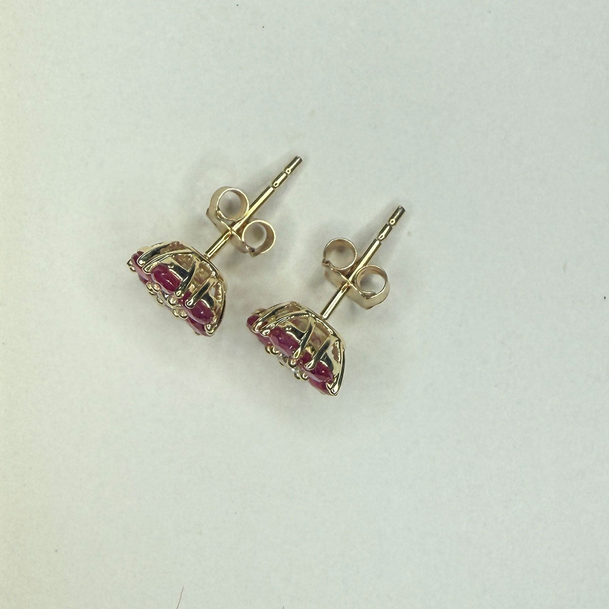 Aretes en oro amarillo 10K en forma de flor con rubíes redondos y diamantes central 0.10ctw