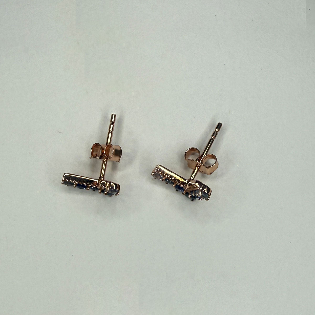 Aretes en forma de V en oro rosa 10K con zafiros y tanzanitas