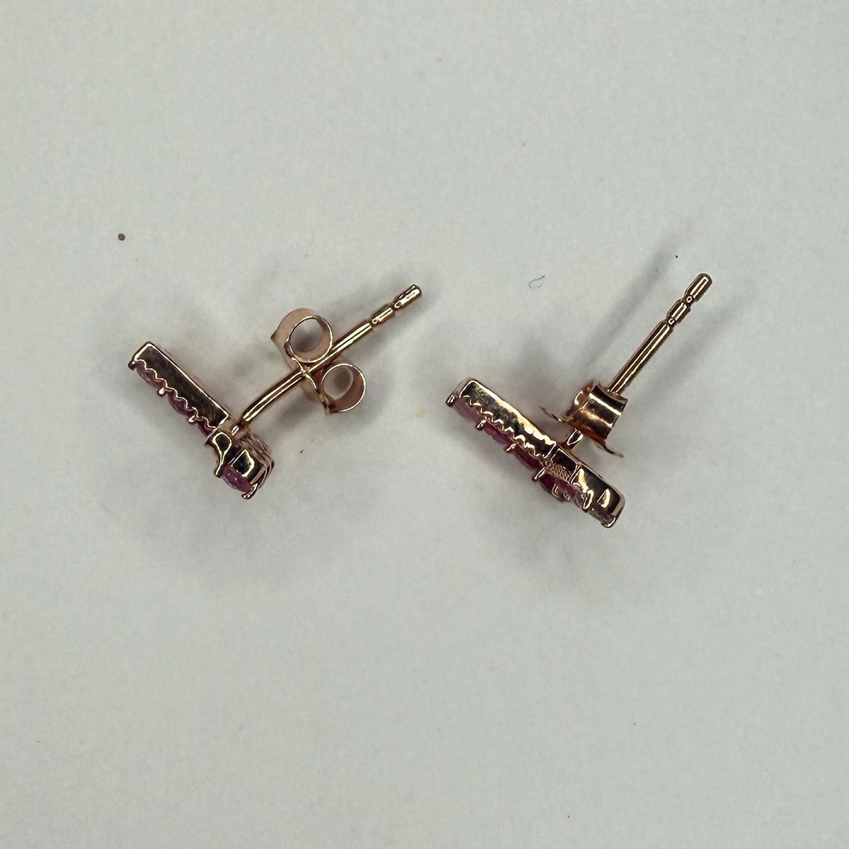Aretes en forma de V en oro rosa 10K con rubíes y zafiros rosa