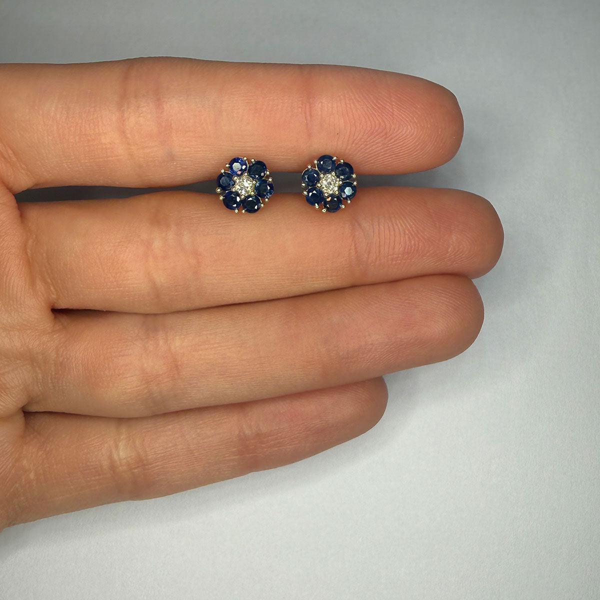 Aretes en oro amarillo 10K en forma de flor con zafiros redondos y diamantes central 0.10ctw