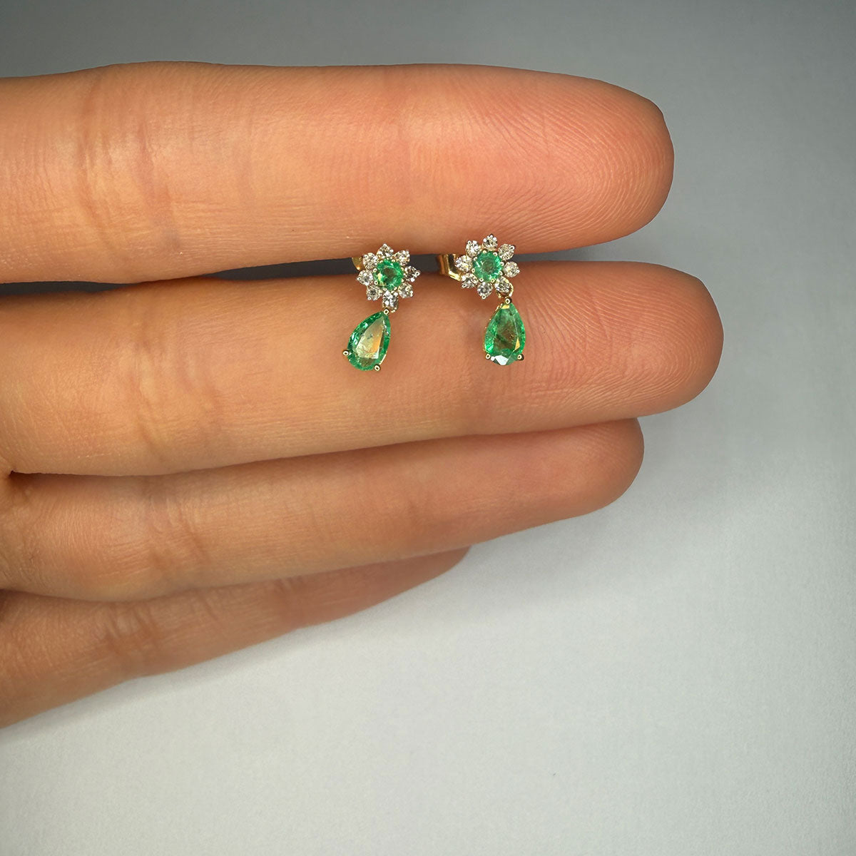 Aretes en oro amarillo 10K con flor de diamantes y centro de esmeralda y gota de esmeralda