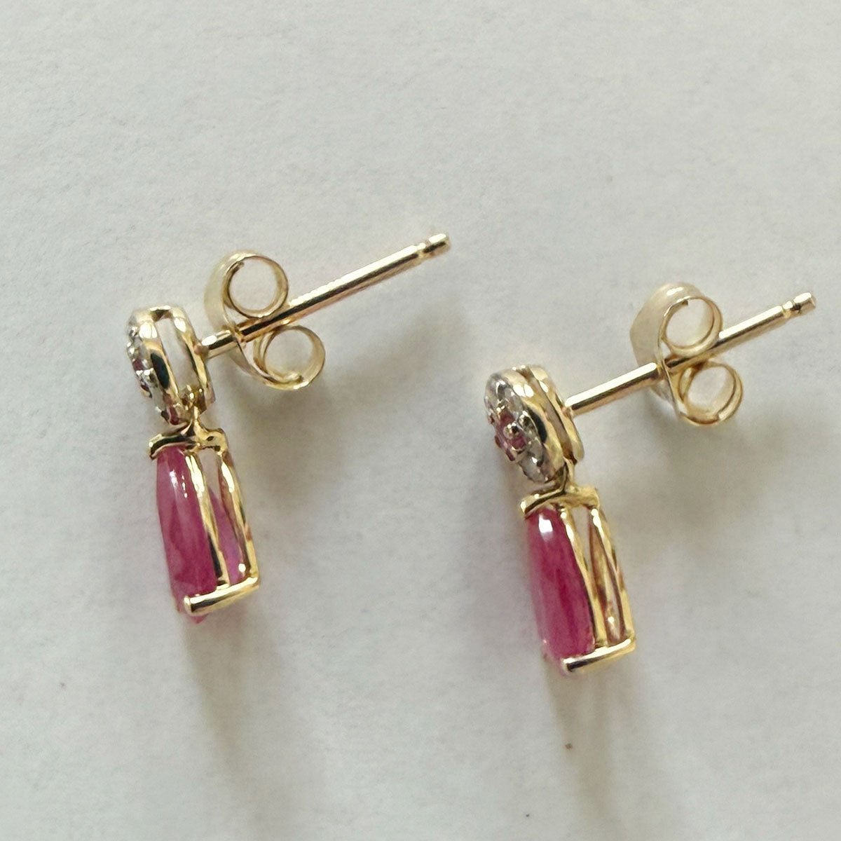 Aretes en oro amarillo 10K con círculo de diamantes y centro de rubí con gota de rubí colgante