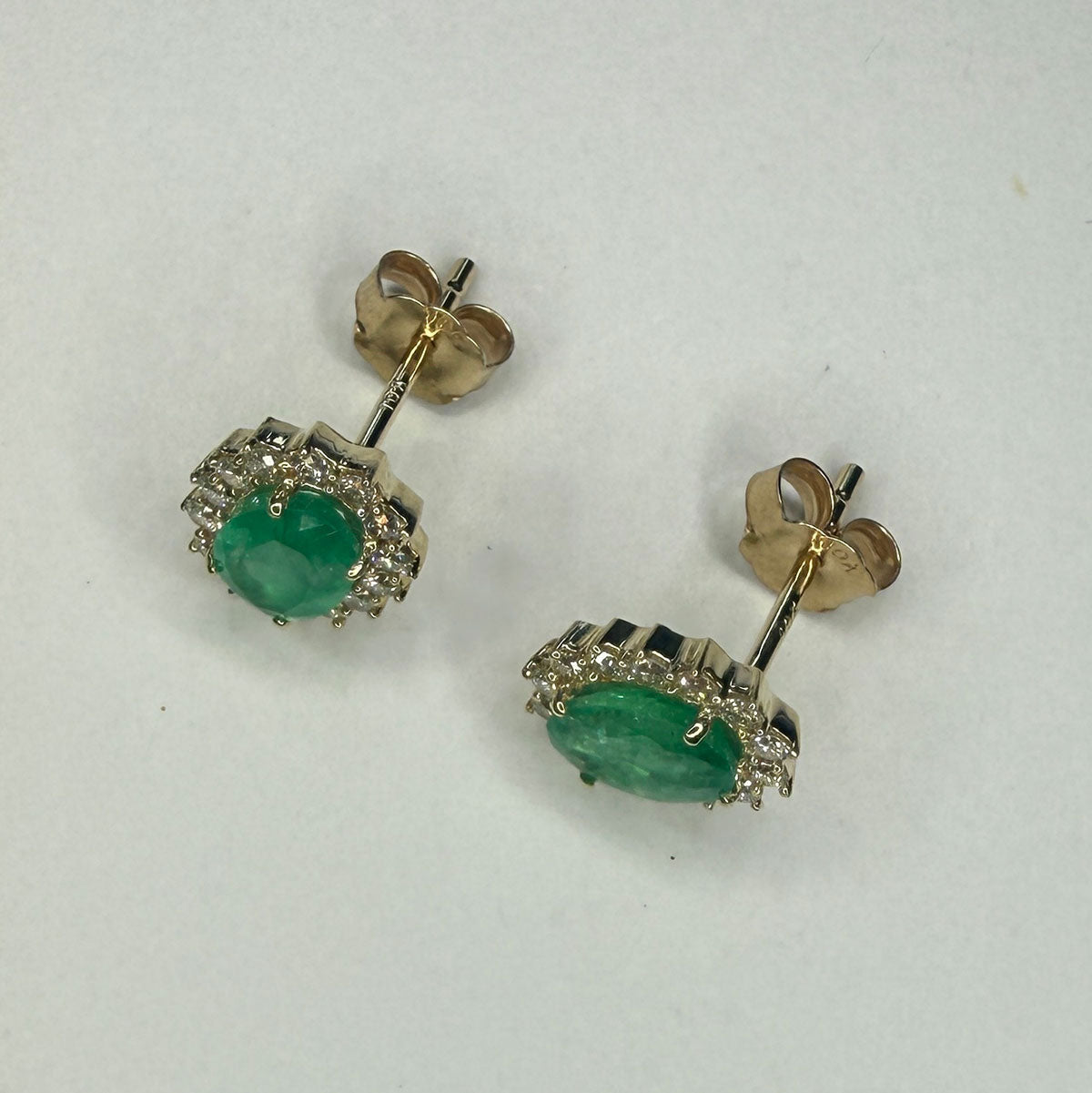 Aretes en oro amarillo 10K con esmeraldas ovaladas y halo de diamantes 0.30ctw