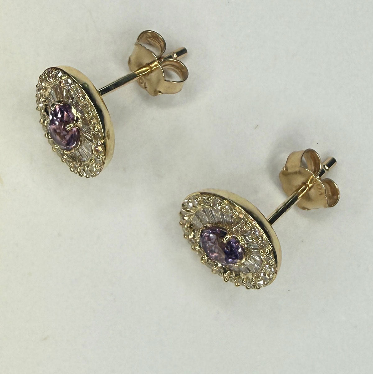 Aretes en oro amarillo 10K con amatista ovalada y halo de diamantes redondos y baguettes 0.40ctw