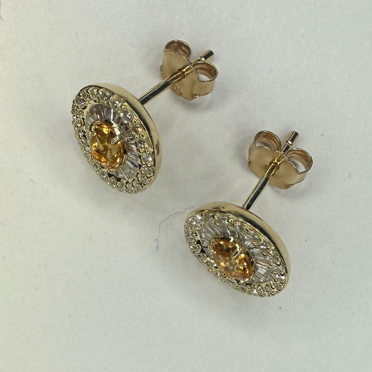 Aretes en oro amarillo 10K con citrino ovalado y halo de diamantes redondos y baguettes 0.40ctw