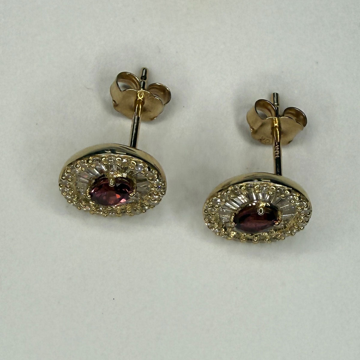 Aretes en oro amarillo 10K con granate ovalado y halo de diamantes redondos y baguettes 0.40ctw