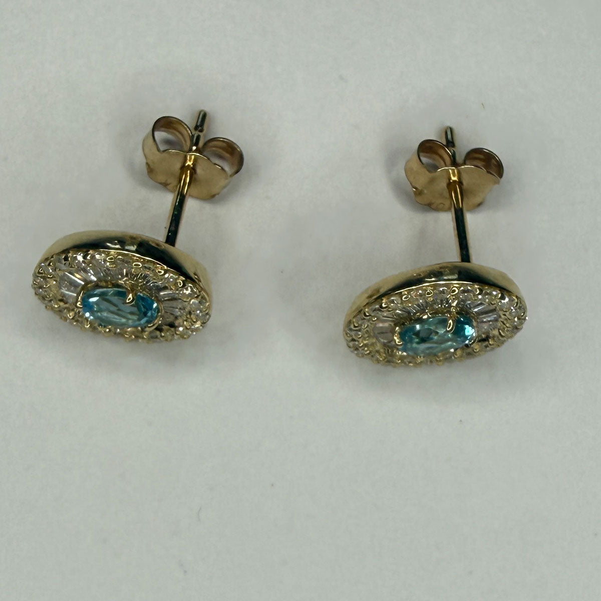 Aretes en oro amarillo 10K con topacio ovalado y halo de diamantes redondos y baguettes 0.40ctw