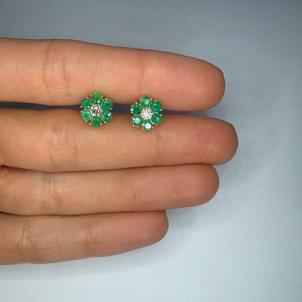 Aretes en oro amarillo 10K con flor de esmeraldas redondas y centro de diamantes 0.20ctw