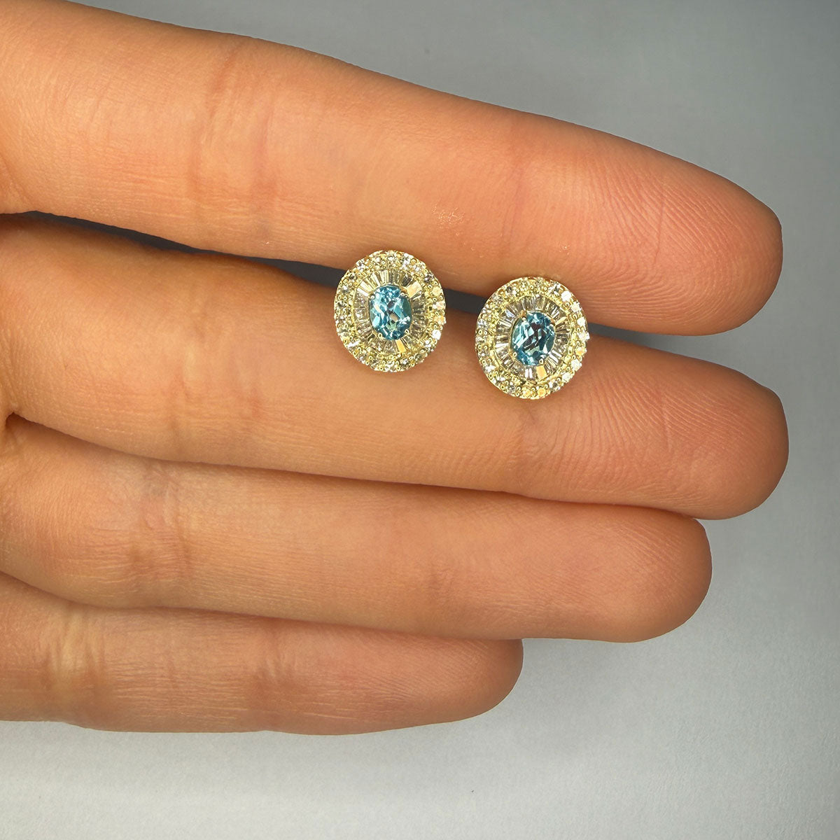 Aretes en oro amarillo 10K con topacio ovalado y halo de diamantes redondos y baguettes 0.40ctw
