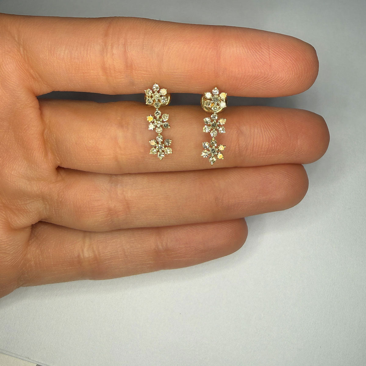 Aretes en oro amarillo 10K con tres flores de diamantes 0.55ctw con broche rosca