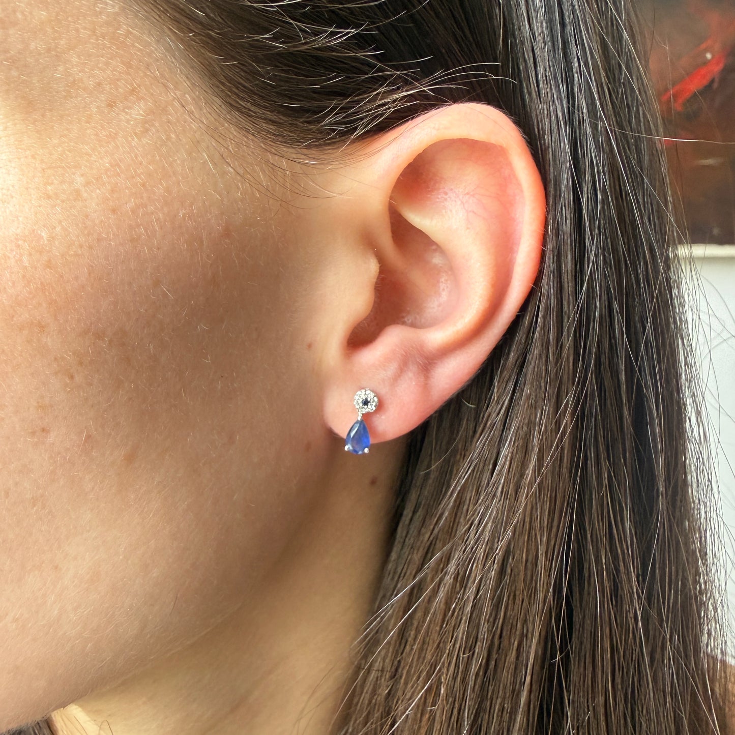 Aretes en oro blanco 10K con círculo de diamantes y centro de zafiro con gota de zafiro colgante