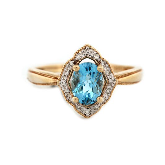 Anillo en oro amarillo 14K con topacio azul ovalado y borde de diamantes 0.10ctw