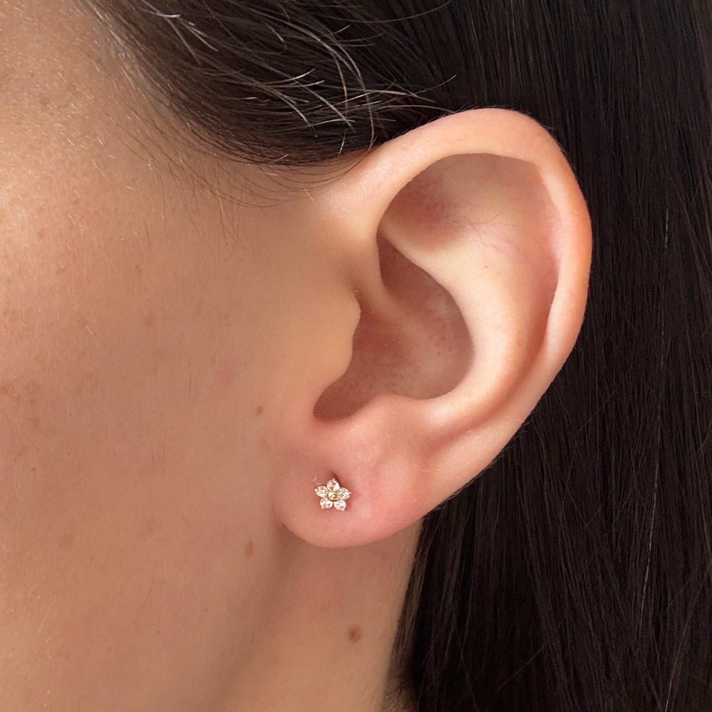 Aretes flor con cinco pétalos de circones blancos en oro amarillo 14K con tope rosca
