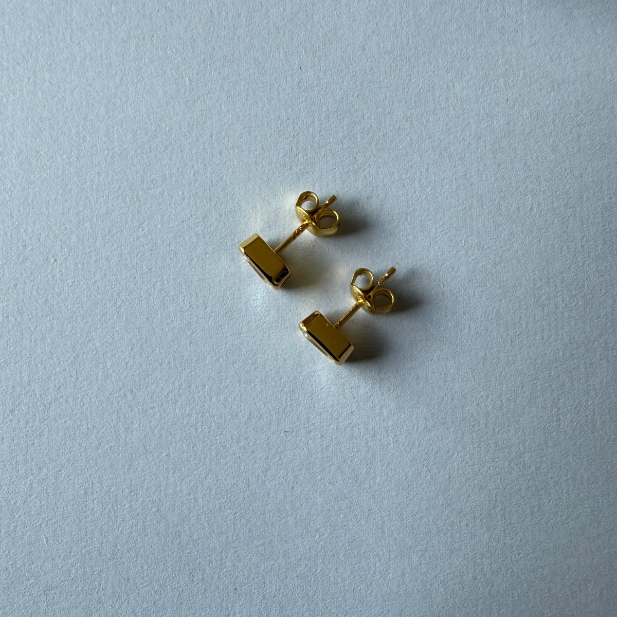 Aretes stud en plata con baño de oro con moissanita corte esmeralda biselada