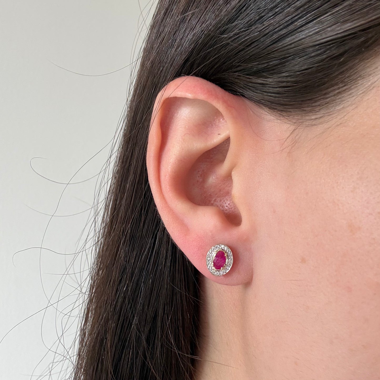 Aretes en oro amarillo 10K con rubí ovalado y halo de diamantes 0.05ctw