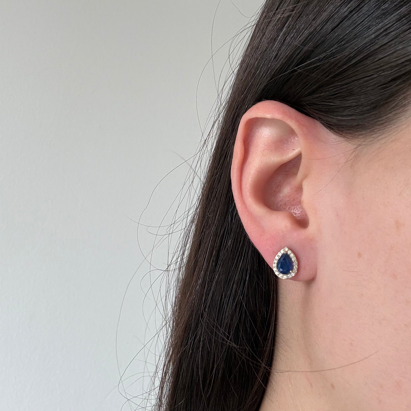 Aretes en oro amarillo 10K con zafiro corte pera y halo de diamantes 0.30ctw con broche rosca