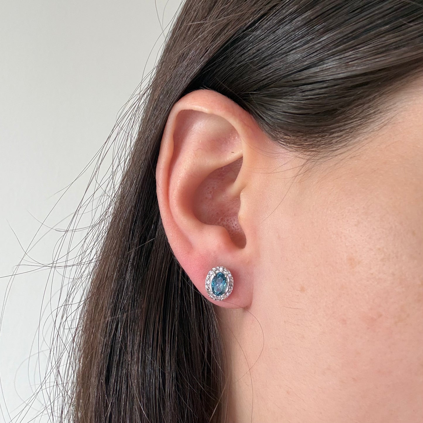 Aretes en oro blanco 10K con topacio london blue ovalado y halo de diamantes 0.09ctw