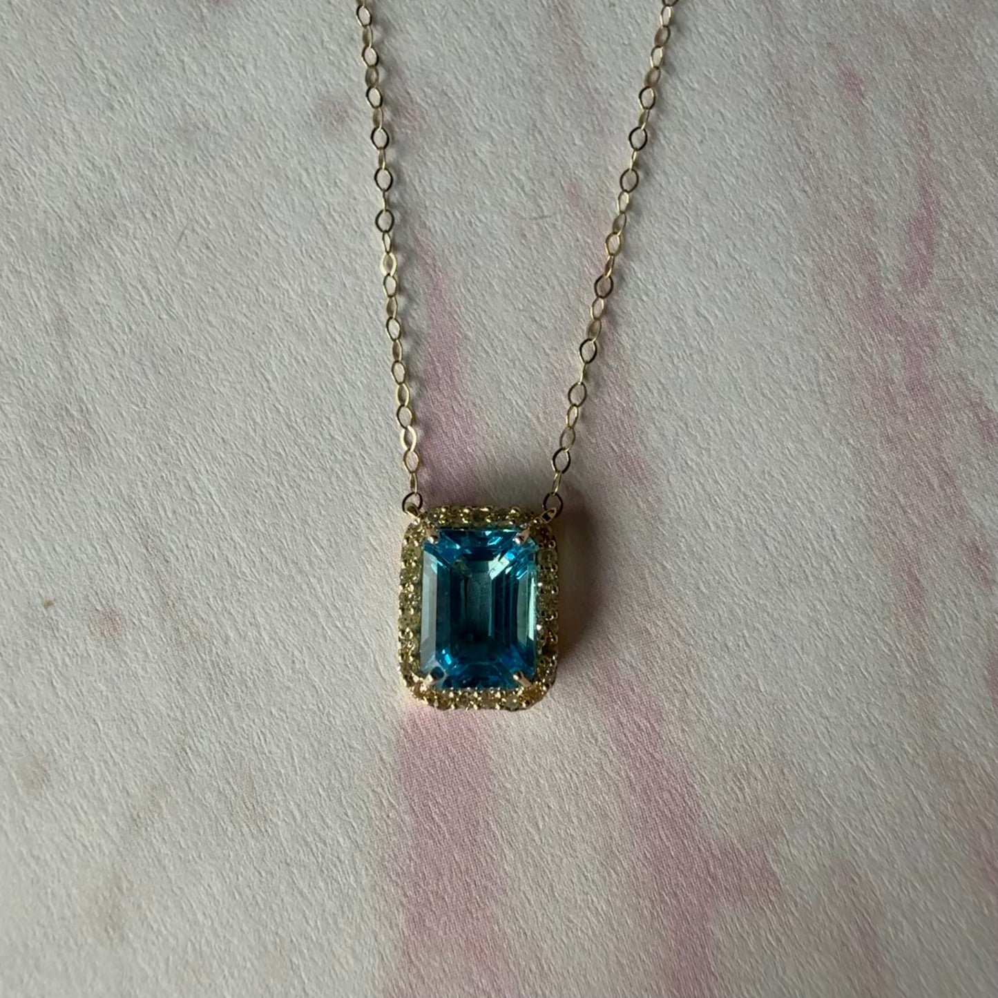Collar en oro amarillo 10K con topacio azul y halo de diamantes 0.11ctw
